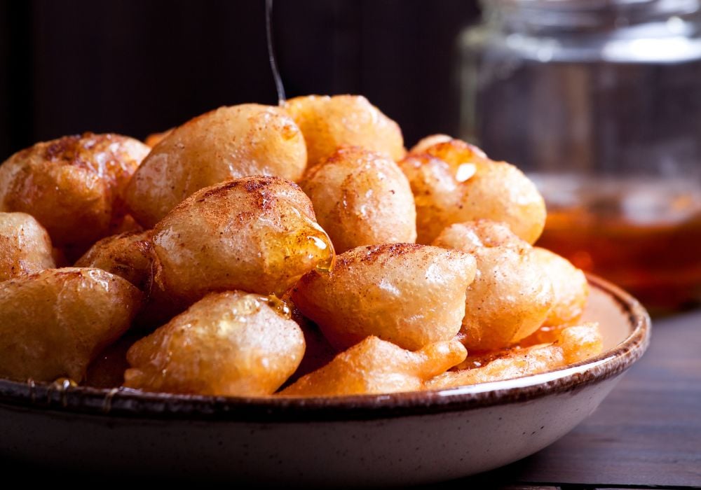 A plate of loukoumades with honey and cinnamon