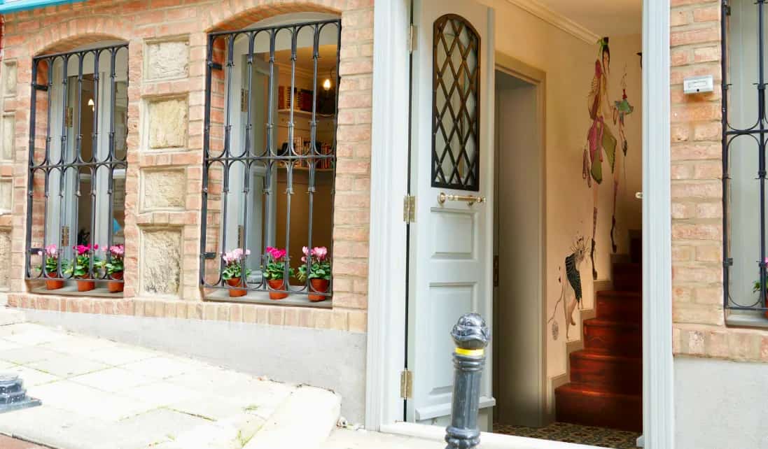 The front exterior of Tilas House hostel in Istanbul, Turkey, featuring an open door on a quiet street